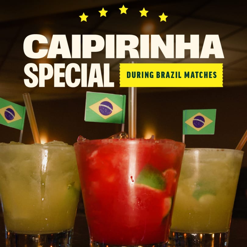 Three caipirinha cocktails, two green and one red, with Brazilian flag picks and straws.